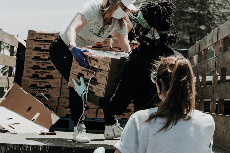 Volunteers loading boxes of strawberries onto a truck